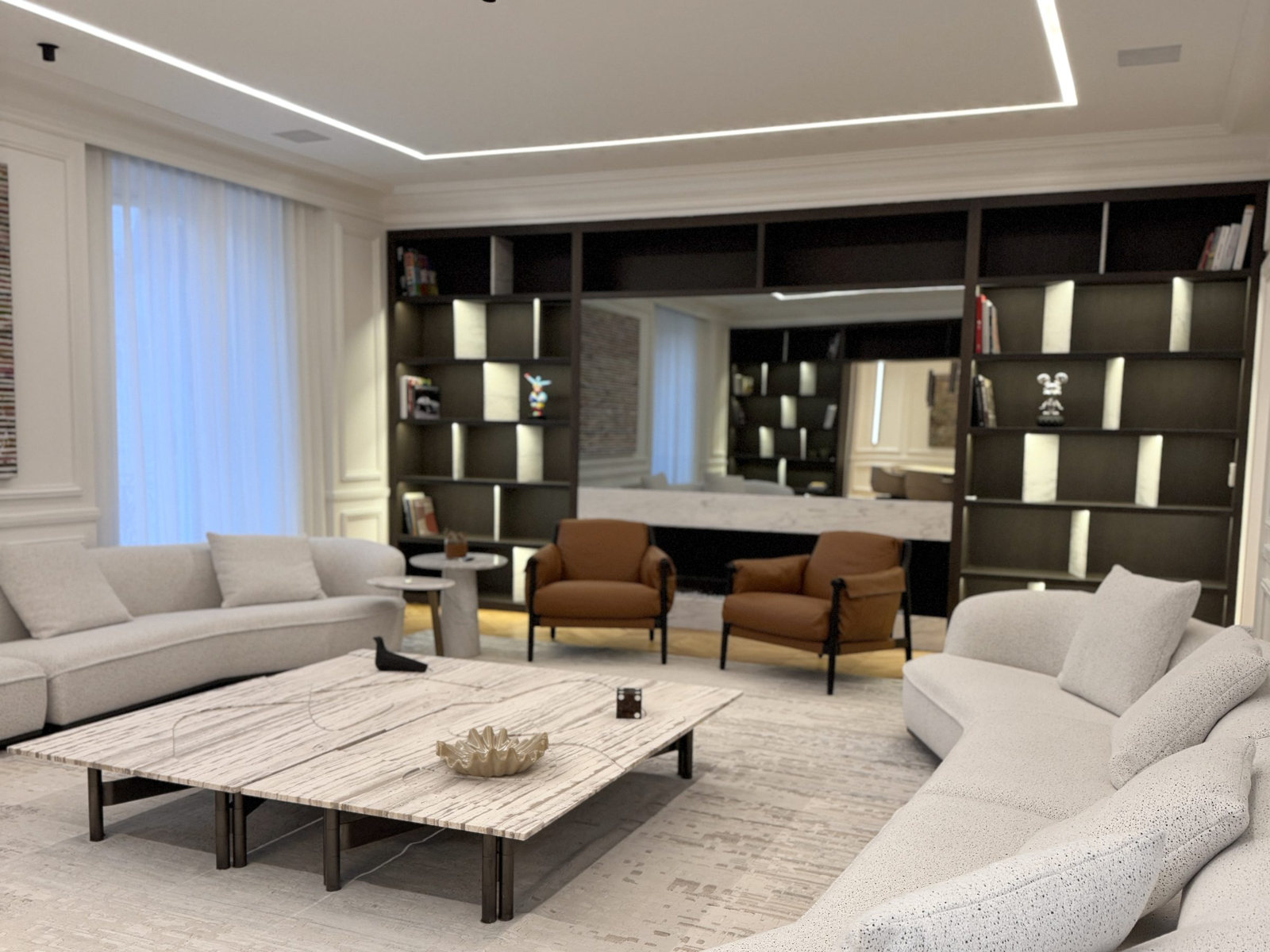 Salon d’un duplex rénové : bibliothèque intégrée toute hauteur, assises courbes et grande table basse en marbre